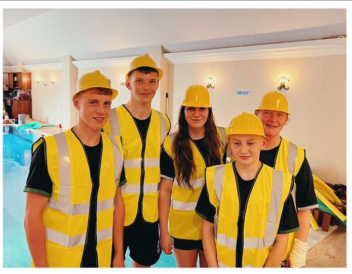 Academy staff wearing yellow hard hats and high-visibility vests for a themed lesson